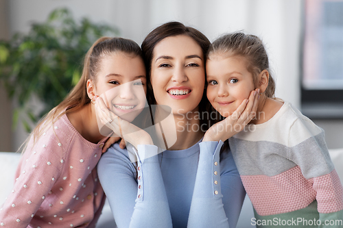 Image of happy smiling mother with two daughters at home