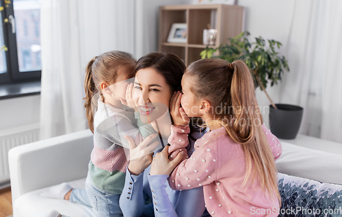 Image of happy mother and daughters gossiping at home