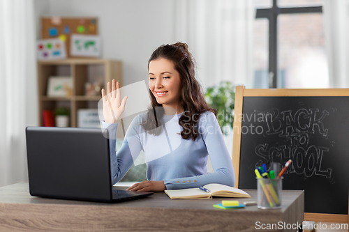 Image of teacher with laptop having online class at home