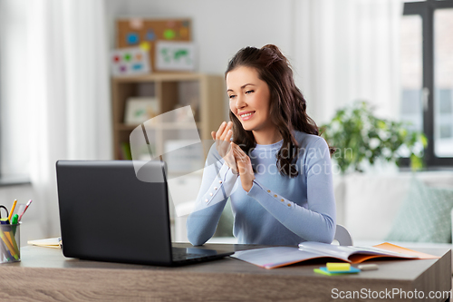 Image of teacher with laptop having online class at home