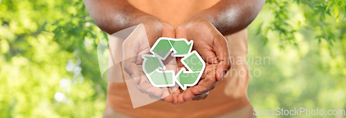 Image of close up of man holding green recycling sign