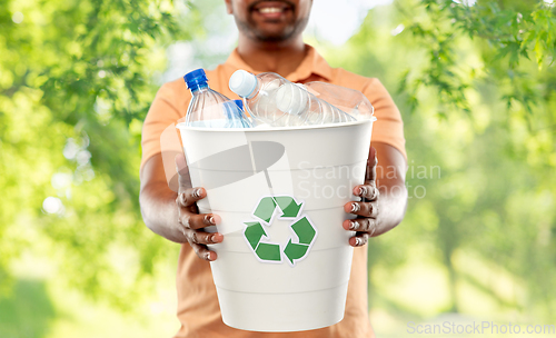 Image of close up of young indian man sorting plastic waste
