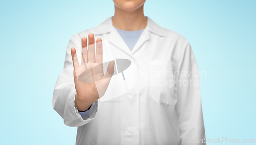 Image of female doctor in white coat showing stop gesture