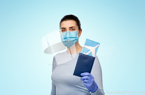 Image of young woman in mask with air ticket and passport