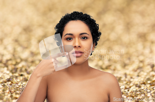 Image of young african american woman pointing to her lips