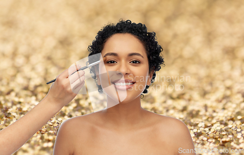 Image of happy woman and hand of make up artist with brush