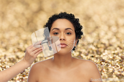 Image of woman and hand of make up artist with brush