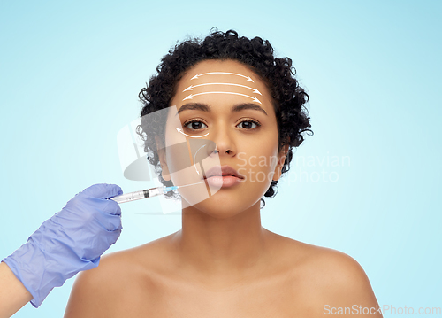 Image of face of african woman and hand with syringe