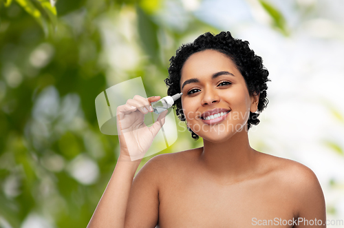 Image of happy young african american woman with eye drops