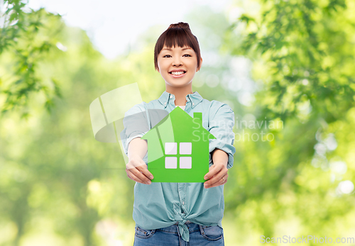 Image of smiling asian woman holding green house