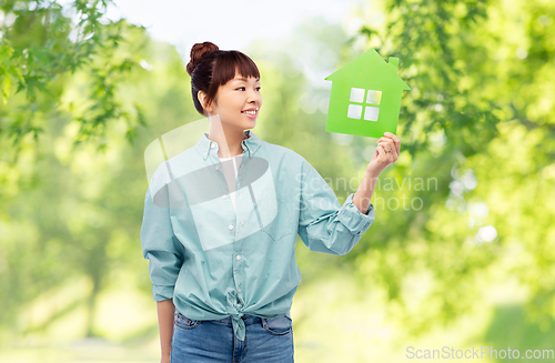 Image of smiling asian woman holding green house