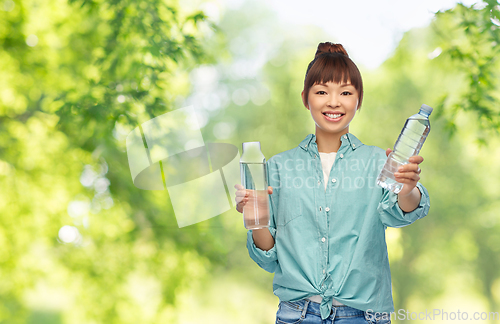 Image of asian woman with plastic and glass bottle of water