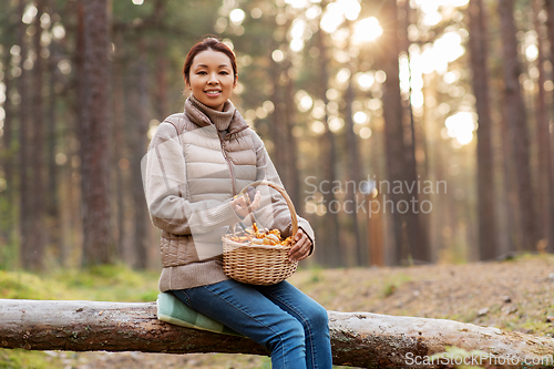 Image of woman with mushrooms in basket in autumn forest