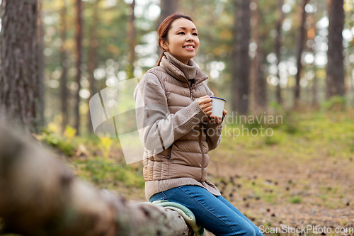 Image of asian woman with mug drinking tea in forest