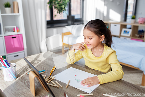 Image of little girl drawing with coloring pencils at home