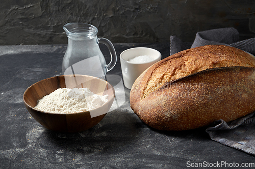 Image of bread, wheat flour, salt and water in glass jug
