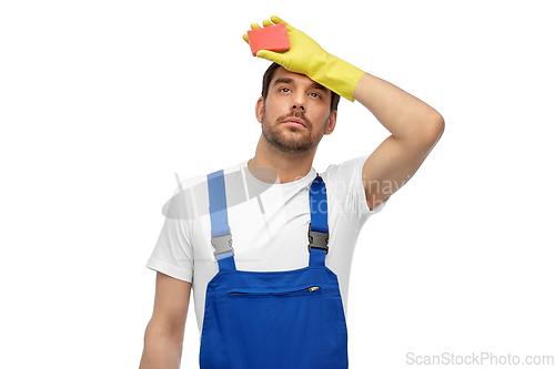 Image of tired male cleaner with sponge