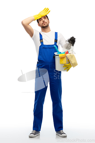 Image of tired male cleaner with cleaning supplies