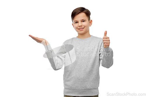 Image of happy boy holding something imaginary on hand