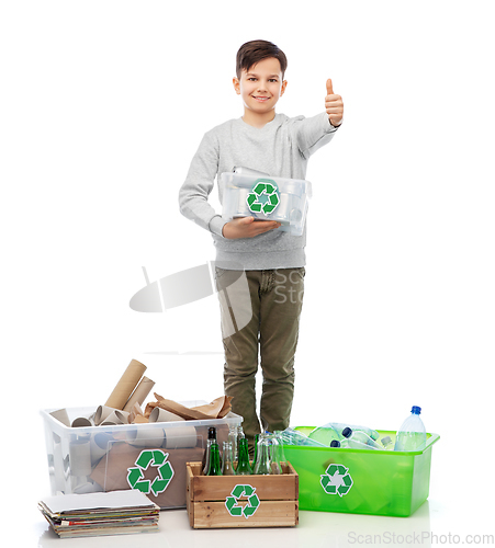 Image of smiling boy sorting paper, metal and plastic waste