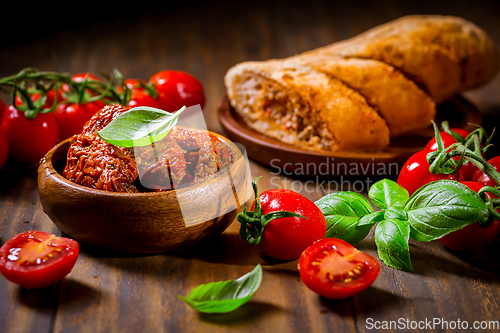 Image of Sun dried and pickled tomatoes with fresh herbs and spices