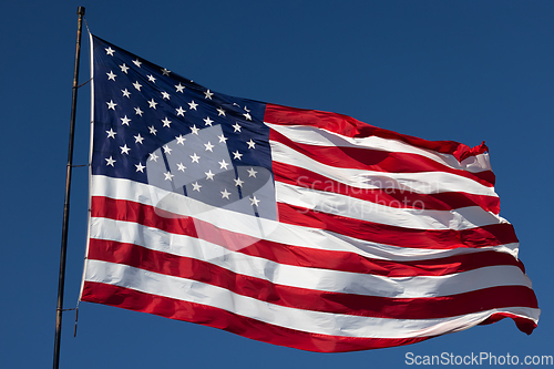 Image of American Flag Waving In Wind Against a Deep Blue Sky