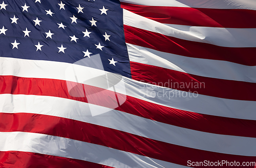 Image of American Flag Waving In Wind Against a Deep Blue Sky