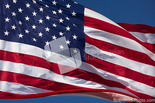 Image of American Flag Waving In Wind Against a Deep Blue Sky