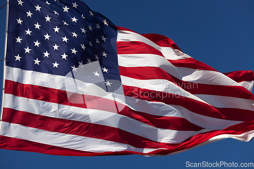 Image of American Flag Waving In Wind Against a Deep Blue Sky