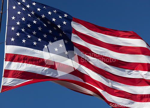 Image of American Flag Waving In Wind Against a Deep Blue Sky