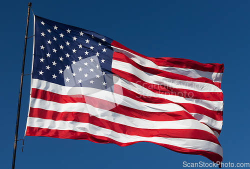 Image of American Flag Waving In Wind Against a Deep Blue Sky