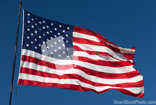 Image of American Flag Waving In Wind Against a Deep Blue Sky