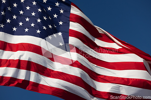 Image of American Flag Waving In Wind Against a Deep Blue Sky