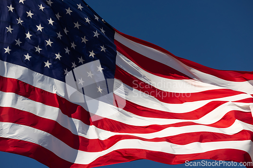 Image of American Flag Waving In Wind Against a Deep Blue Sky