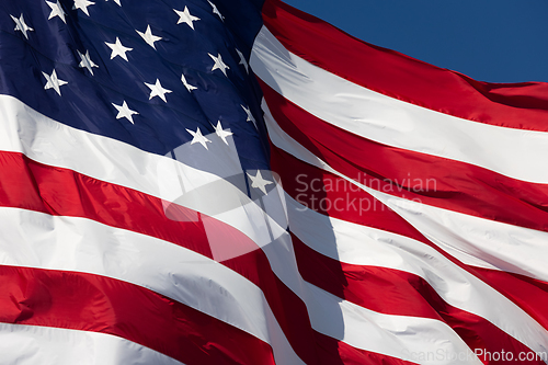 Image of American Flag Waving In Wind Against a Deep Blue Sky