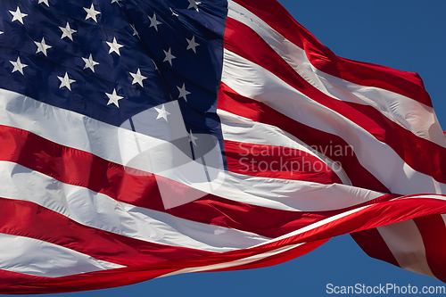 Image of American Flag Waving In Wind Against a Deep Blue Sky