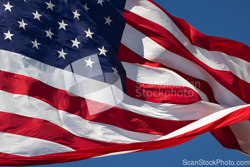 Image of American Flag Waving In Wind Against a Deep Blue Sky