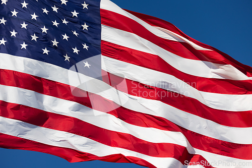 Image of American Flag Waving In Wind Against a Deep Blue Sky