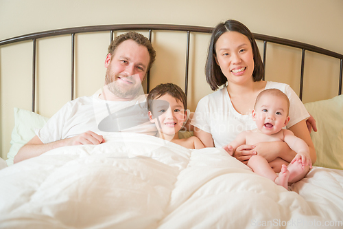 Image of Mixed Race Chinese and Caucasian Baby Boys Laying In Bed with Th