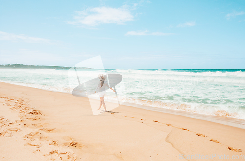 Image of Woman walking along the beach on beautiful summer day in Austral