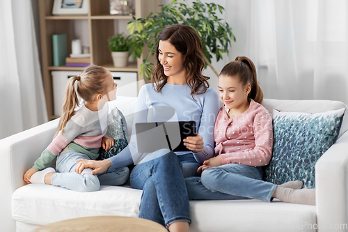 Image of happy mother and daughters with tablet pc at home