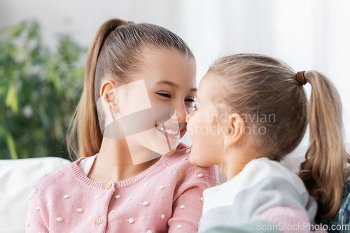 Image of two happy smiling little girls or sisters at home