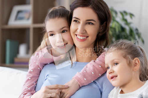 Image of happy smiling mother with two daughters at home