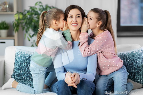 Image of happy mother and daughters gossiping at home