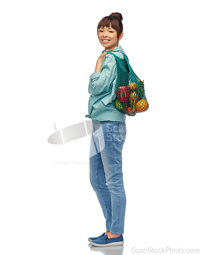 Image of happy asian woman with food in reusable string bag