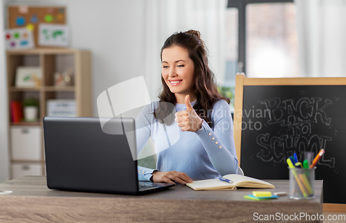 Image of teacher with laptop having online class at home