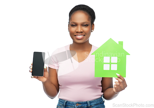 Image of african woman with smartphone and green house