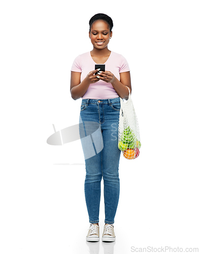 Image of woman with smartphone and food in string bag