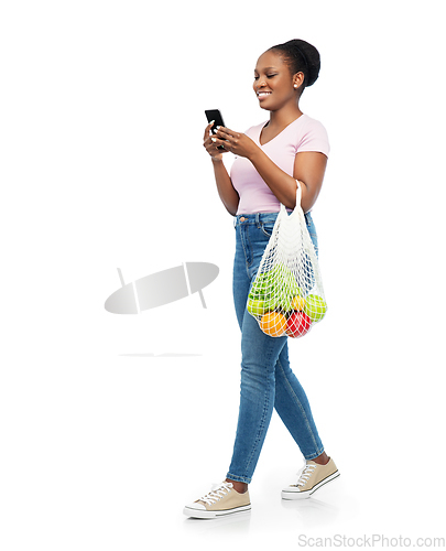 Image of woman with smartphone and food in string bag