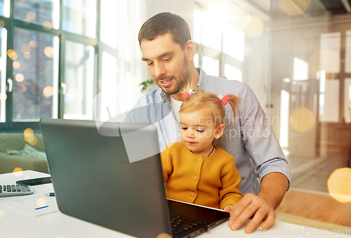 Image of working father with baby daughter at home office